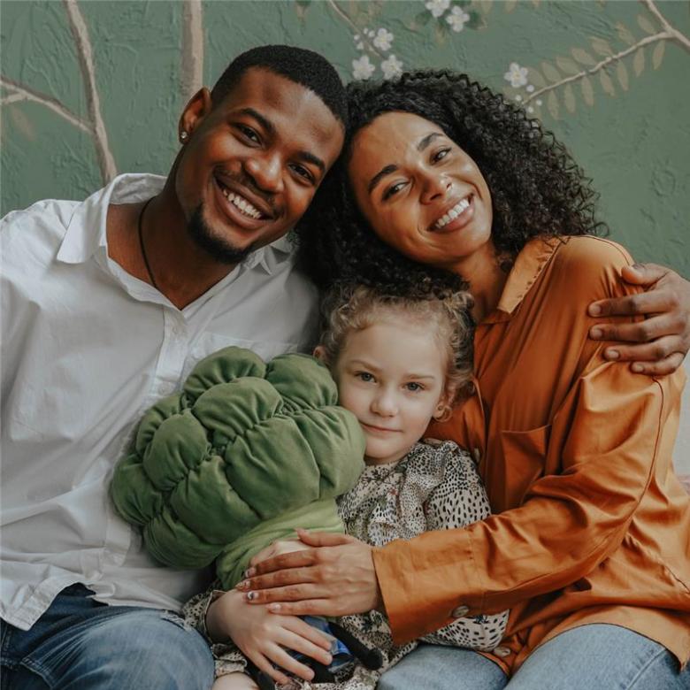 A man and a woman hugging each other and a child