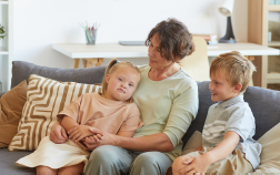 A woman and two kids sitting on a couch