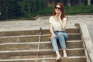 A blind woman sitting on stairs